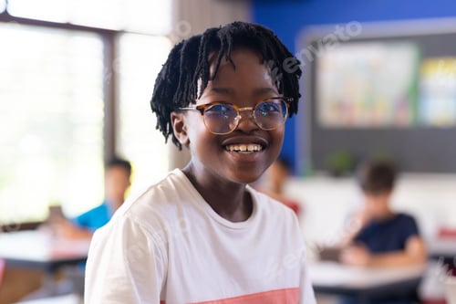 Preview: Wearing glasses, smiling boy enjoying school environment in classroom