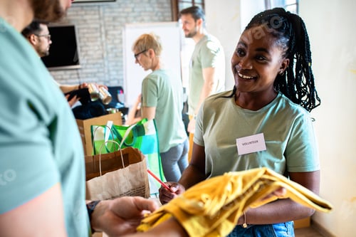 Preview: Group of volunteers with working in community charity donation center.