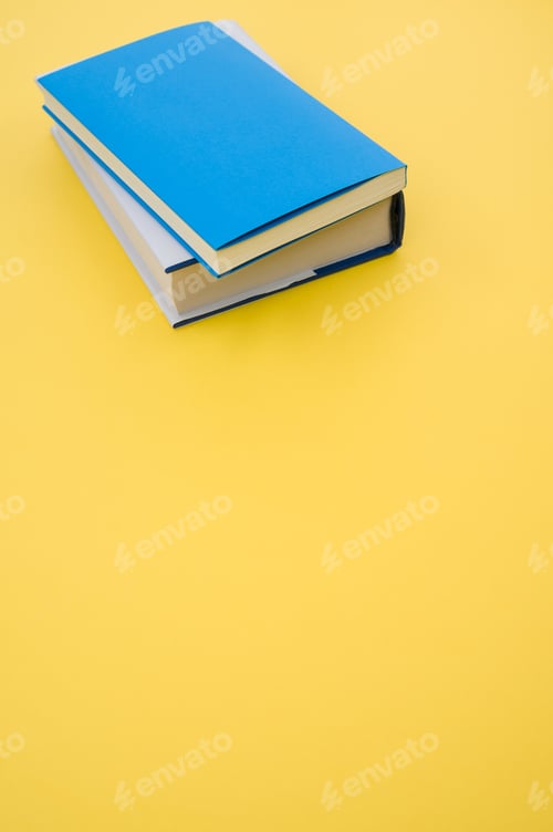 Preview: Closeup of the hardcover books on the yellow surface - space for text