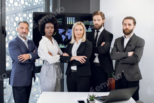 Preview: Front view of multiethnical focused successful diverse team of male and female workers, standing in