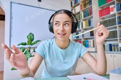 Preview: Webcam view of teenage girl, high school student, in headphones, talking to camera
