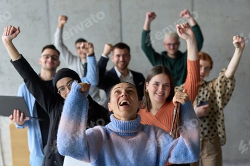 Preview: A diverse team of business professionals ecstatically celebrating their success in a modern office