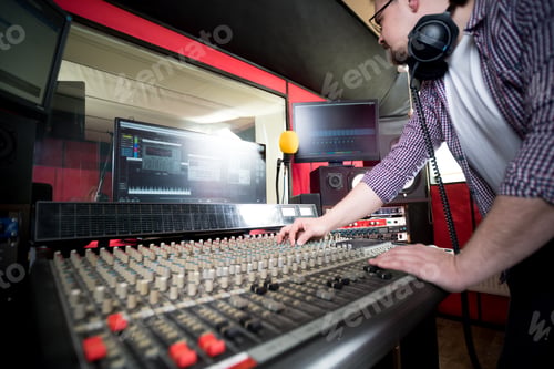 Preview: Sound producer working at recording studio using soundboard and monitors