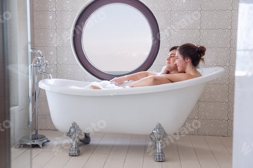Preview: A loving couple takes a bubble bath in a minimalist white, modern interior. Young girl hugs a man