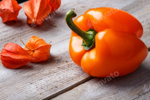 Preview: orange pepper and physalis on a wooden background