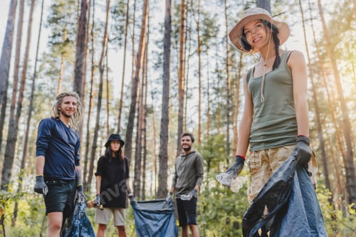 Preview: Portrait of group friends with bags picking up trash outdoor. Ecology concept