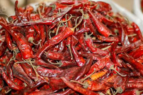 Preview: Big bucket filled with red spicy chilli peppers in the market