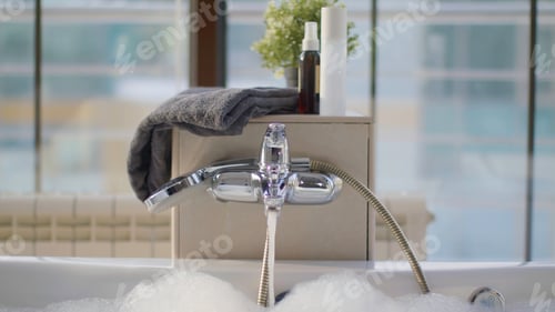 Preview: Luxurious bubble bath with clear warm water flowing from the faucet, spa concept. Stock footage