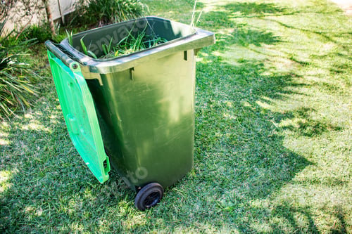 Preview: Green bin container filled with garden waste. Spring clean up in the garden.