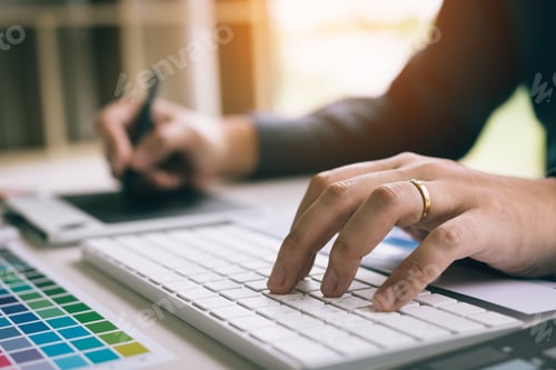 Preview: Designers are at the desk using computer and finger typing to the keyboard.