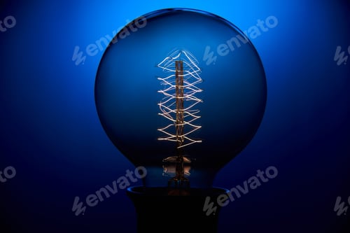 Preview: Electric vintage Edison light bulb with a spiral on a blue background. Retro style lamp