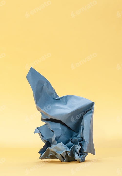 Preview: Crumpled blue paper on a pastel yellow background.