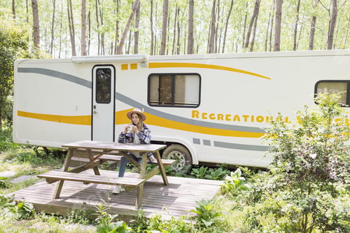 Preview: caucasian woman with blonde hair drinking morning coffee during summer adventure in camping