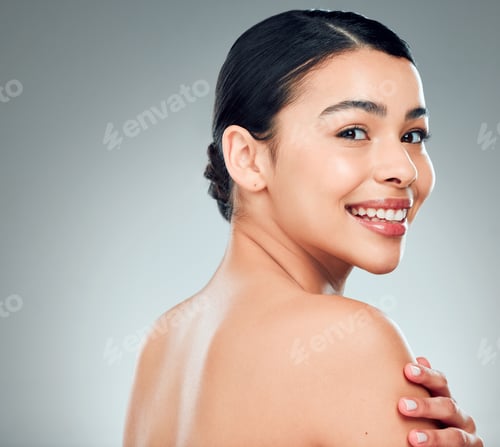Preview: Portrait of a beautiful mixed race woman touching smooth soft skin in a studio. Hispanic model with