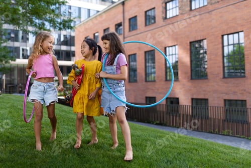 Preview: Happy kids playing and talking together in city park, during summer day.