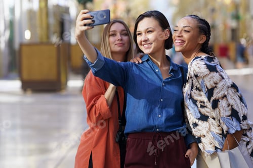 Preview: Joyful multiethnic women taking selfie on smartphone