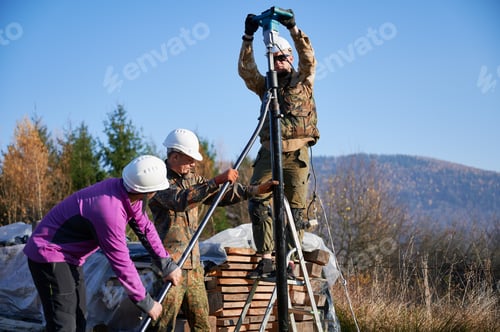 Preview: Male workers building pile foundation for wooden frame house.