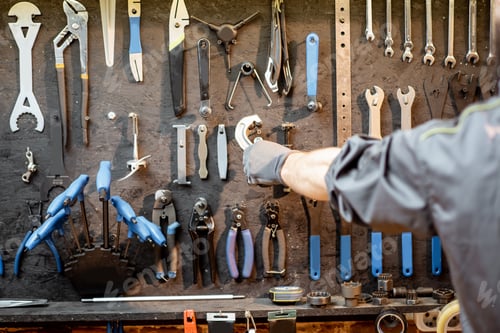 Preview: Man taking working tools from the wall