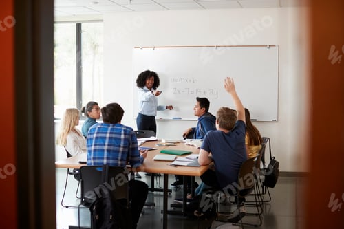 Preview: Female High School Tutor At Whiteboard Teaching Maths Class With Pupil Asking Question