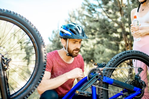 Preview: Sports man repairing mountain bicycle outdoors