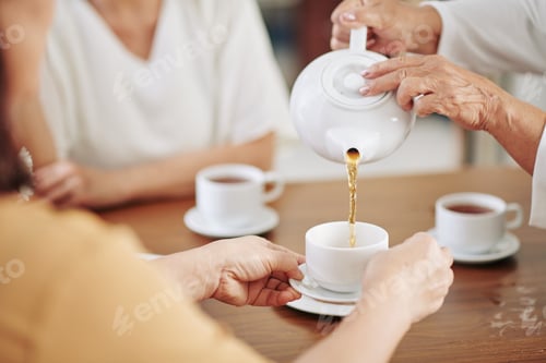 Preview: Senior woman pouring hot tea