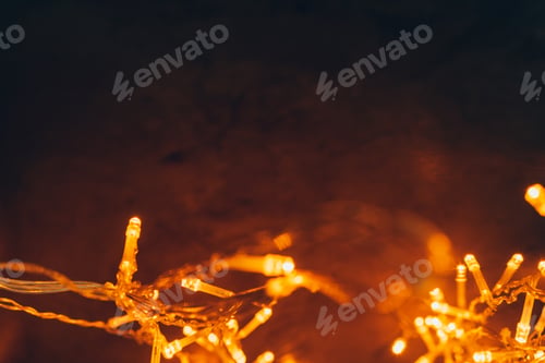 Preview: Warm light illuminated garland close up on dark background