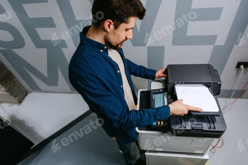 Preview: Office worker using a multifunction printer to print documents in a modern workspace