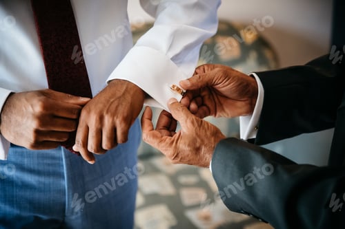 Preview: Men standing side by side in suits, adjusting their cuffs a gesture of camaraderie