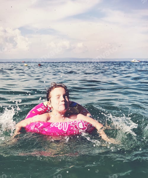 Preview: The girl swims in a lifebuoy. Splashing around.