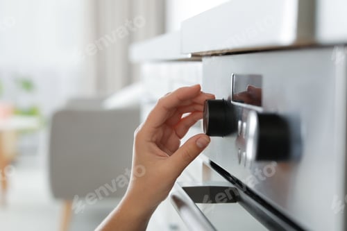Preview: Woman regulating cooking mode on oven panel, closeup