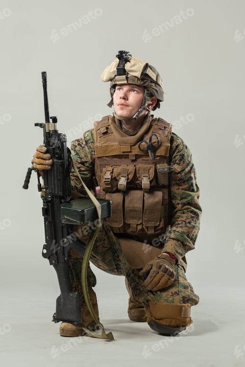 Preview: Soldier in military gear poses with rifle in studio setting during daytime
