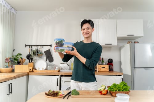 Preview: Portrait of man cooking healthy foods in kitchen in morning at home.