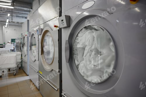 Preview: A row of washing machines is perfectly lined up in a laundromat