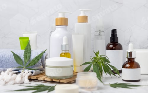 Preview: Blank cosmetic jars, tubes and bottles near green cannabis leaves close up, CBD cosmetic mockup
