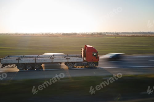 Preview: Aerial view of blurred fast moving semi-truck with cargo trailer driving on highway
