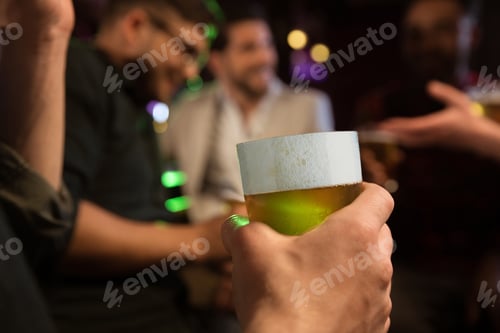 Preview: Close-up of man's hand holding glass of beer