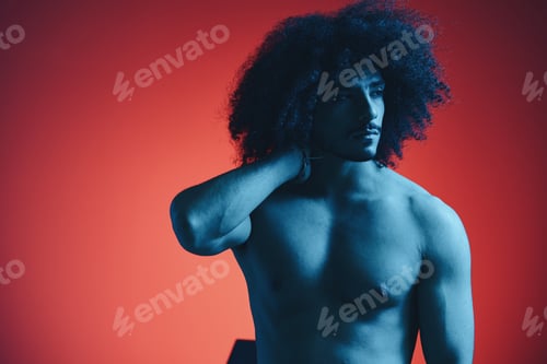 Preview: Portrait of fashion man with curly hair on red background with stylish glasses, multinational