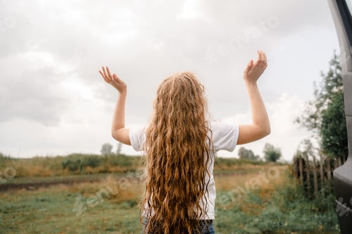 Visualização: Criança risonha abre os braços e pega gotas de chuva.