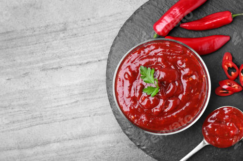 Preview: Flat lay composition with hot chili sauce on grey background. Space for text