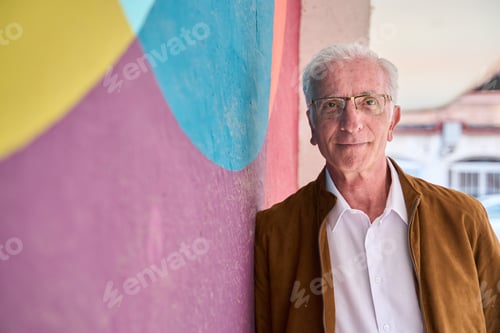 Preview: Senior man smiling standing colorful urban background