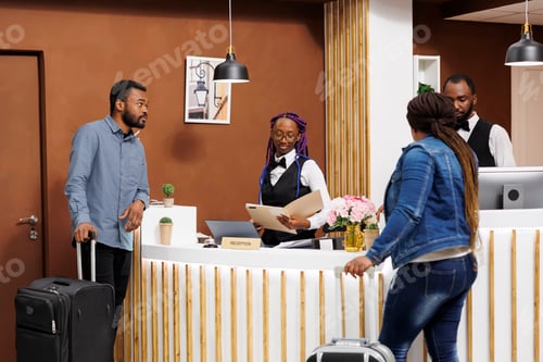 Preview: Hotel receptionist checking guests in