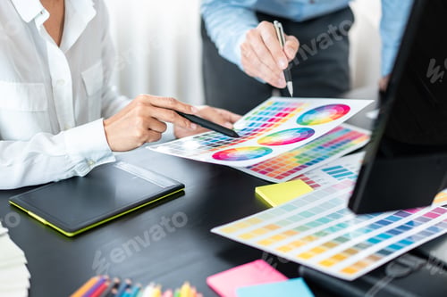 Preview: Two creative graphic designer team working on color selection and drawing on graphic tablet
