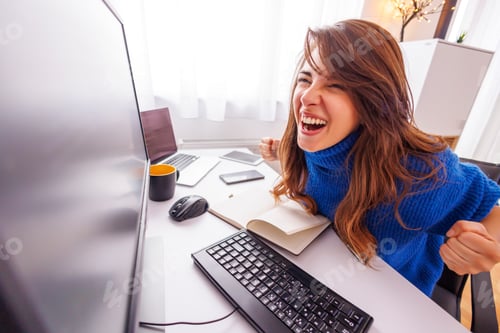 Preview: Female software developer celebrating success while working from home