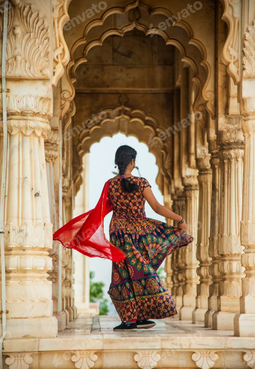 Preview: Young female tourist dancing between arches and Pillars.