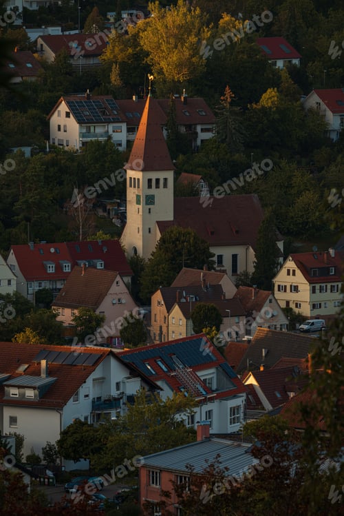 Preview: Evening cityscape of Botnang, a Stuttgart suburb, with warmly lit homes nestled among rolling hills