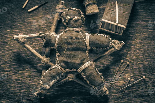 Preview: Closeup of voodoo doll pierced by a needle as harming
