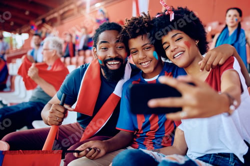 Preview: Happy black family taking selfie with cell phone at the stadium.