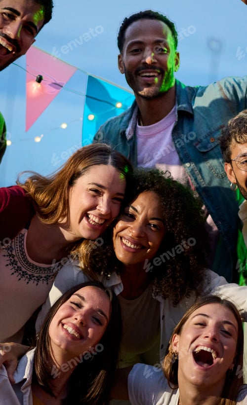 Preview: Portrait of excited young diverse people posing for photo at party night