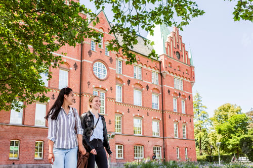 Preview: Female students walking in front of library.