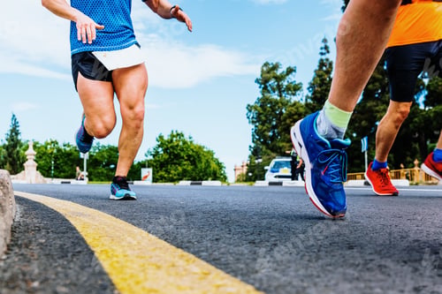 Preview: Powerful legs and quadric muscles of a runner in full effort running on the asphalt